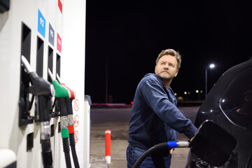 Man filling gasoline fuel in car. Hand refuelling the car, pumping gasoline fuel in automobile at...