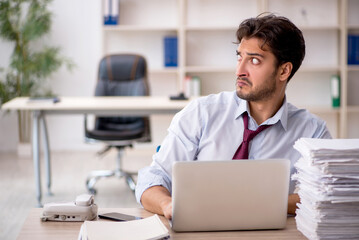 Young male employee and too much work in the office