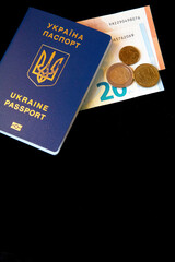 Ukrainian passport with european money on dark background. Copy space. Vertical view