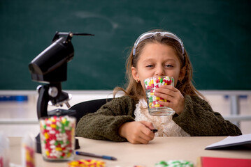 Young little girl chemist in drugs synthesis concept