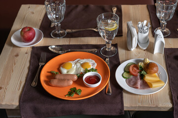Fried eggs with sausages and tomato sauce.