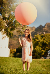 Any bigger and it would carry me away. Portrait of a cute little girl holding a huge balloon while...