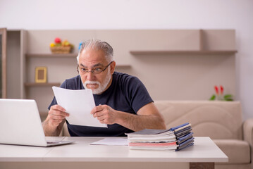 Obraz premium Old male employee working from home during pandemic
