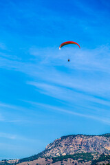 A tourist paraglider flying over the mountain top