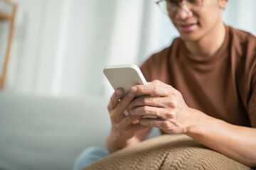 Relaxed young asian man using smart phone  spending time checking news social media