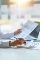Businesswoman sitting planning analyze investment and marketing on the desk in the office.