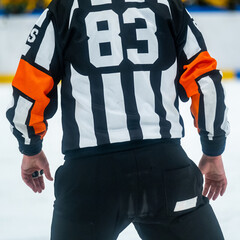 Closeup of an ice hockey referee watching the game on the sideline