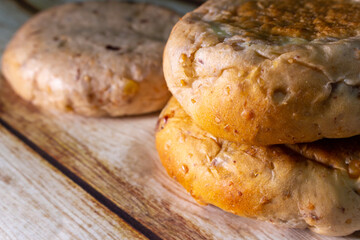 Closeup a couple of homemade walnut breads on the wooden shabby thick table. Simple, organic and minimal conceptual image.