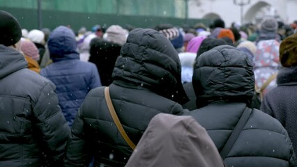 A crowd of migrants is walking along a city street.