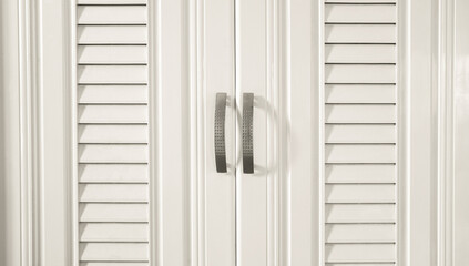 Background of a small white horizontal door with a linear design running through it and an opening...