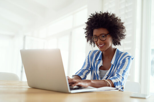 Self-employed And Totally Loving It. Cropped Shot Of A Young Woman Working On Her Laptop At Home.