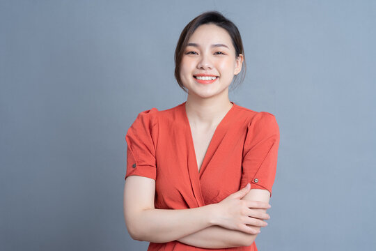 Young Asian woman posing on gray background