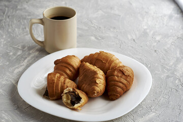 a plate of croissants and a cup of coffee on the table