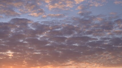 Beautiful evening blue sky at sunset with flaming bright light clouds. A warm summer evening at sunset. Bright sunset.