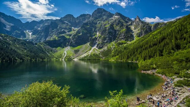 Poland mountains morskie oko Eye of the Sea a lake surrounded by mountains top peek views clear clean lake timelapse white clouds shadows floating by near town of zakopane in Tatra Mountains