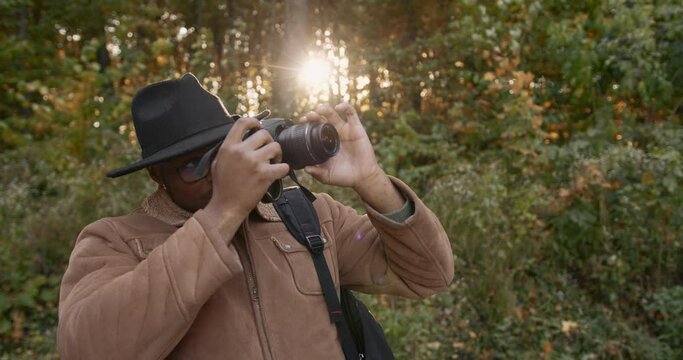 A young black traveler shoots the forest on camera
