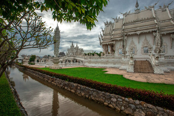 background Wat Rong Khun The White Temple and pond with fish, in Chiang Rai, Thailand