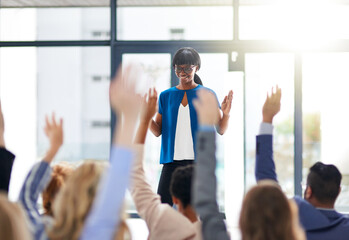 Fototapeta premium Leading and learning. Cropped shot of a group of people raising their hands in a class.