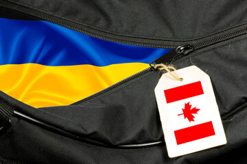 Ein Koffer und Flaggen von Ukraine und Kanada