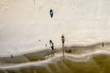 Morze Bałtyckie, widok z lotu ptaka z drona lecącego nad pustą, piękną plażą. Drobne fale rozbijające się o piaszczystą plażę.