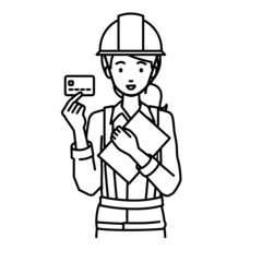 立って書類とカードを手に持つ工事現場の女性