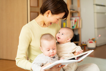 絵本を読む母親と双子の赤ちゃん