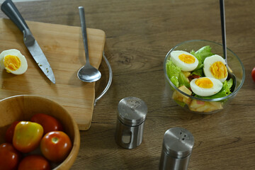 Above view vegetarian salad with boiled egg in glass bowl on wooden table. Healthy food concept.
