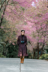 Fototapeta na wymiar girl with bright pink cherry blossoms in winter