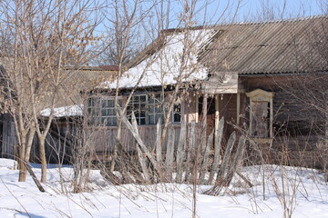 Abandoned by people and destroyed by time wooden house and fence