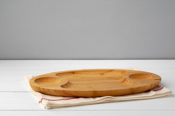 Wooden cutting board on cotton napkin on white wooden table