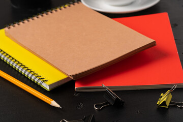 Three notepads on a black table close up
