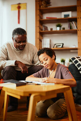 A grandfather tutoring grandchild at home.