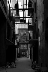 Fototapeta na wymiar A dark alley in a black and white Asian monotone skyscraper in the middle of the city.