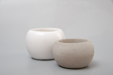 White spherical porcelain and gray cement vase on a gray background. Minimalism. Design. 