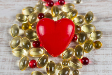 Red heart and omega 3 pills. Cardio vascular disease concept.