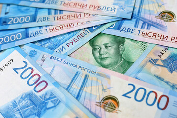 Chinese yuan banknote surrounded by russian rubles. Concept of economic cooperation between the China  and Russia, trading and support
