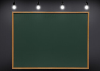 Glowing light bulbs and green chalkboard hanging on grey wall