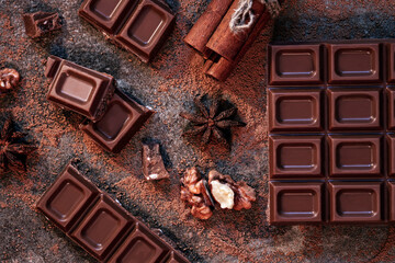 dark chocolate pieces and bar with cocoa, nuts, cinnamon, top view, high quality studio shot
