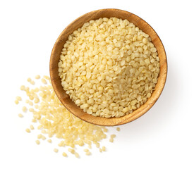 Raw hemp seeds in the wooden bowl, isolated on the white background, top view.