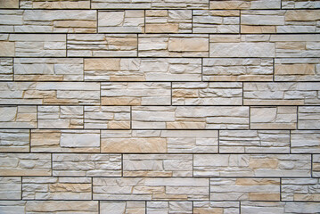 Background of beige bricks. Wall of beige bricks. The texture of the wall. Texture of beige decorative tiles in form of brick.