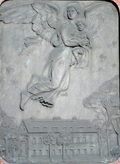 An old sandstone relief which shows a  female angel who takes a child away from a manor house to heaven.