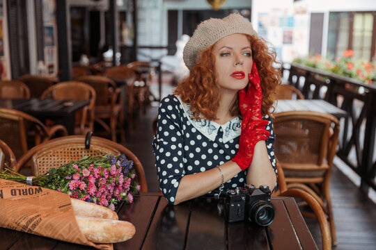 Close up portrait of a woman in a beret and vintage dress at the cafe