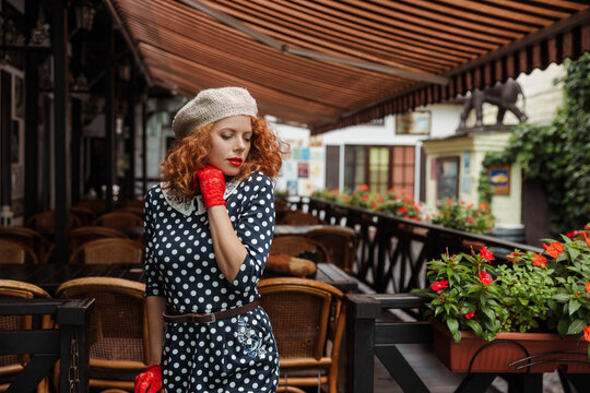 Close up portrait of a woman in a beret and vintage dress at the cafe