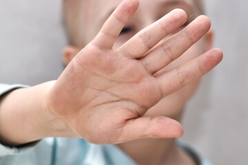 Gesturing the stop sign.
Young boy making stop gesture with his hand. Stop the War. Stop the Pandemic. Selective focus