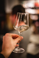 hand with a glass of white wine at a wine tasting