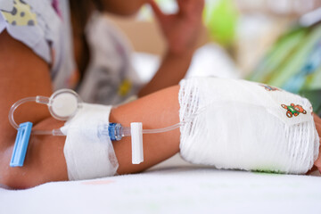 Girl hand with drip infusion lying on bed.