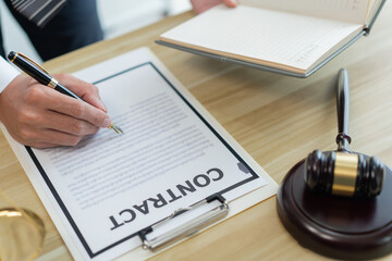 Law consultancy concept A male lawyer making clear of some details by adding clearer description on the contract by himself.