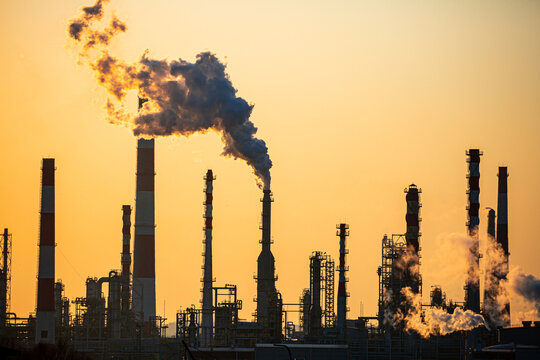 Working oil refinery. Smoke from the factory chimney. Ecological pollution. Air emissions polluting the city. Industrial waste is hazardous to health. Large factory in smog, Production in operation.