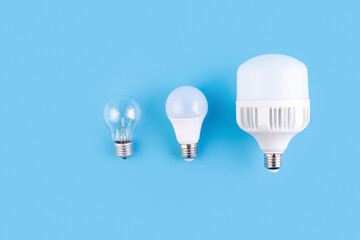 incandescent lamp and led lamps against on isolated blue background. Energy efficiency concept....