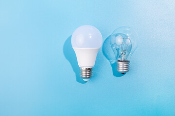incandescent lamp and led lamp against on isolated blue background. Energy efficiency concept. Flat lay. Concept ecology, save planet earth, idea, save energy, economy, saving. Earth day